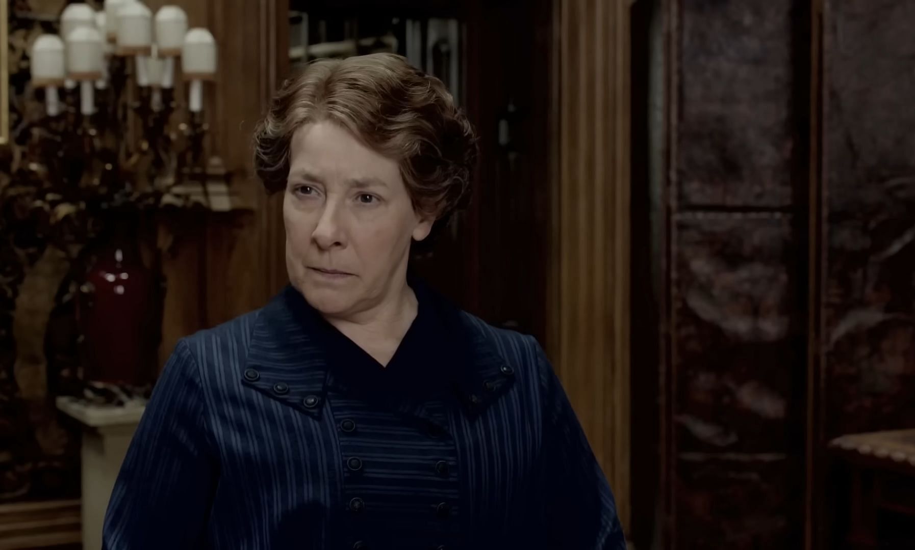 Phyllis Logan portrays Downton Abbey’s housekeeper, Mrs. Hughes (Image via YouTube/Downton Abbey)